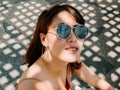 Beautiful Asian women wearing sunglasses and earrings look up to the sunshine Royalty Free Stock Photo