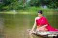 Woman wearing Thai traditional dress sitting on bamboo raft Royalty Free Stock Photo