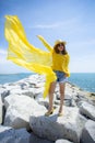 Beautiful asian woman wearing yellow clothes standing on sea beach against midday sun light