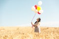 Beautiful asian woman in a wheat field with air balloons Royalty Free Stock Photo