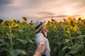 Beautiful asian woman in white dress holding hands a couple in sunflower field