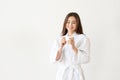 Beautiful Asian woman in white robe with coffee, relaxing after taking shower Royalty Free Stock Photo