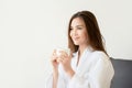 Beautiful Asian woman in white robe holding cup of coffee Royalty Free Stock Photo