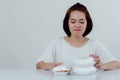 Beautiful Asian woman, white shirt Sitting in front of the dining table There is an expression of disgust in the foam box. Do not