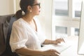 Beautiful Asian woman work from home, working on computer in living room at home.