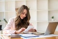 Beautiful Asian woman working on a laptop computer at the office. businesswoman looking at financial statistics data analysis char Royalty Free Stock Photo