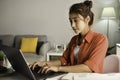 Beautiful Asian woman working on laptop at home. Female student sitting on desk study online on laptop take notes in notebook Royalty Free Stock Photo