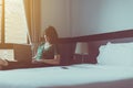 Beautiful Asian woman working on laptop while sitting on chair in bedroom with flare light,Happy and smiling,Enjoying time,P Royalty Free Stock Photo