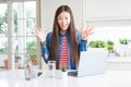 Beautiful Asian woman working using computer laptop celebrating crazy and amazed for success with arms raised and open eyes Royalty Free Stock Photo