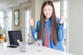 Beautiful Asian woman working using computer laptop celebrating surprised and amazed for success with arms raised and open eyes Royalty Free Stock Photo