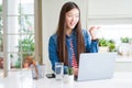 Beautiful Asian woman working using computer laptop pointing and showing with thumb up to the side with happy face smiling Royalty Free Stock Photo