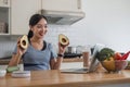 Beautiful Asian woman in workout clothes searches for healthy recipes online on her laptop. while preparing healthy food Royalty Free Stock Photo