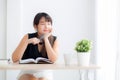 Beautiful asian woman writer smiling thinking idea and writing on notebook or diary with happy on desk office Royalty Free Stock Photo