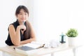 Beautiful asian woman writer smiling thinking idea writing on notebook diary with planning working on desk office Royalty Free Stock Photo