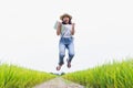 Beautiful asian women are happy and jumping in the rice field and are holding a laptop mockup Royalty Free Stock Photo