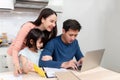 Beautiful asian women Lovely girl Looking at the laptop screen Of handsome men working online on the desk at home, a new normal