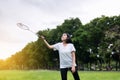 Beautiful asian woman playing badminton in nature in the morning,Happy and smiling