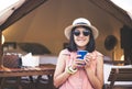 Beautiful asian woman sitting at tent and drinking coffee in the morning,Enjoys of resting time,Happy and smiling Royalty Free Stock Photo
