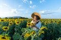 A beautiful asian women in a white dress and hat walking on a field of sunflowers , smiling a beautiful smile,cheerful girl,style Royalty Free Stock Photo