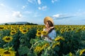 A beautiful asian women in a white dress and hat walking on a field of sunflowers , smiling a beautiful smile,cheerful girl,style Royalty Free Stock Photo