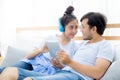 Beautiful asian young couple listening to music with tablet on bedroom. Royalty Free Stock Photo