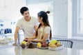 Beautiful asian young couple is looking to cooking in kitchen at Royalty Free Stock Photo