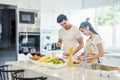 Beautiful asian young couple loving smiling is looking to cooking in kitchen at home,Happy handsome man washing vegetables in the Royalty Free Stock Photo