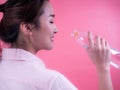 Beautiful asian young woman drinking a bottle of water isolated on a pink background Royalty Free Stock Photo