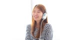 Beautiful asian young woman enjoy and fun listen music with headphone sitting in bedroom Royalty Free Stock Photo