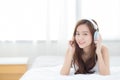 Beautiful asian young woman enjoy listen music with headphone while lying in bedroom. Royalty Free Stock Photo