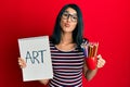 Beautiful asian young woman holding art notebook and colored pencils looking at the camera blowing a kiss being lovely and sexy Royalty Free Stock Photo