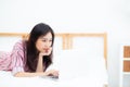 Beautiful asian young woman lying on bed using laptop at bedroom for leisure and relax, freelance with girl working notebook, Royalty Free Stock Photo