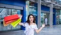Beautiful asian young woman with shopping bags with smile while standing at the clothing store. Happiness, consumerism, sale and Royalty Free Stock Photo