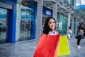 Beautiful asian young woman with shopping bags with smile while standing at the clothing store. Happiness, consumerism, sale and Royalty Free Stock Photo