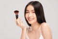 Beautiful Asian young woman smile and holding make up brush