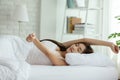 Beautiful Asian young Woman stretching her arm after wake up on bed in cozy bedroom feeling so fresh and relax in the morning, Royalty Free Stock Photo
