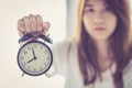 Beautiful asian young woman wake up in morning annoyed alarm clock holding hand Royalty Free Stock Photo