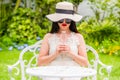 Beautiful Asian young woman wear hat and sunglasses holding glass of pure water Royalty Free Stock Photo