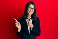 Beautiful asian young woman wearing business suit smiling and looking at the camera pointing with two hands and fingers to the Royalty Free Stock Photo