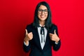 Beautiful asian young woman wearing business suit success sign doing positive gesture with hand, thumbs up smiling and happy Royalty Free Stock Photo