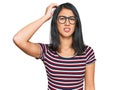 Beautiful asian young woman wearing casual clothes and glasses confuse and wonder about question Royalty Free Stock Photo