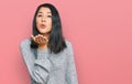 Beautiful asian young woman wearing casual clothes looking at the camera blowing a kiss with hand on air being lovely and sexy Royalty Free Stock Photo