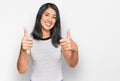 Beautiful asian young woman wearing casual white t shirt approving doing positive gesture with hand, thumbs up smiling and happy Royalty Free Stock Photo