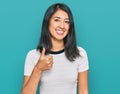 Beautiful asian young woman wearing casual white t shirt doing happy thumbs up gesture with hand Royalty Free Stock Photo