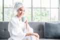 Beautiful asian young woman in white dress sitting on couch and smile with holding coffee cup and drinking in spa room Royalty Free Stock Photo