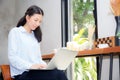 Beautiful asian young woman working online on laptop sitting at coffee shop Royalty Free Stock Photo