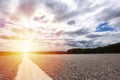 Beautiful asphalt road around farm fields and grassland in rural landscape at sunset  White line on the road with clouds and blue Royalty Free Stock Photo