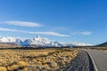 Beautiful asphalt road Route 40 with background of Fitz Roy and Cerro Torre peak snow mountain in the morning blue sky with golden