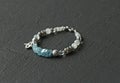 Beautiful asymmetrical designer bracelet made of natural stones and silver. Aquamarine, rock crystal, cacholong, larimar, Royalty Free Stock Photo