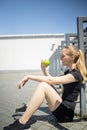 Beautiful athletic blonde woman eating a green apple after workout Royalty Free Stock Photo